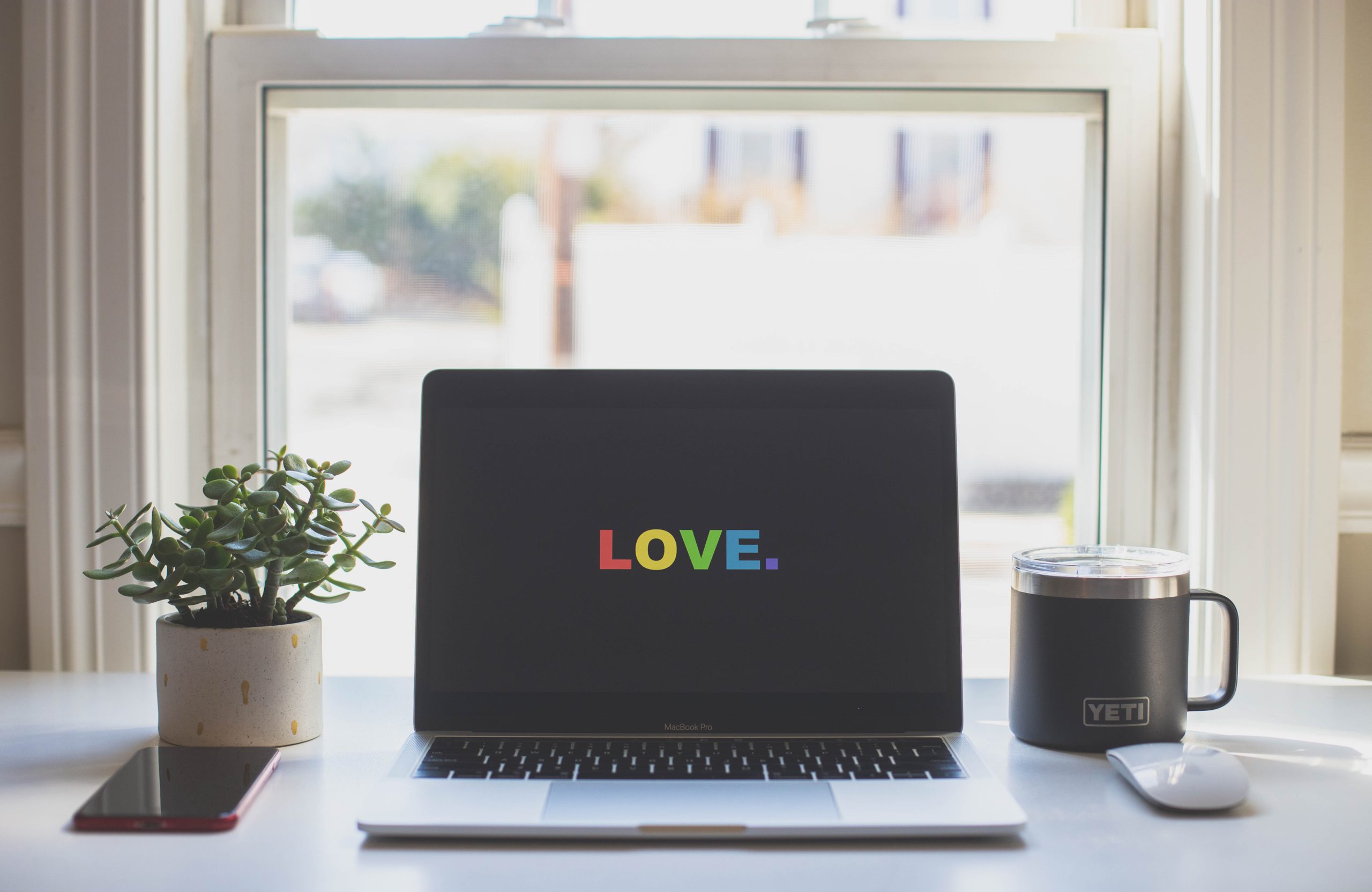 computer with the word "love" in rainbow colors