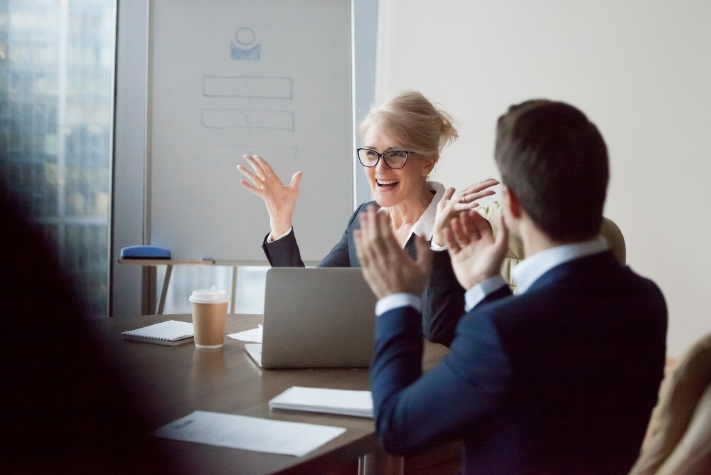 Employees celebrating a colleague’s success, illustrating employee recognition reporting.