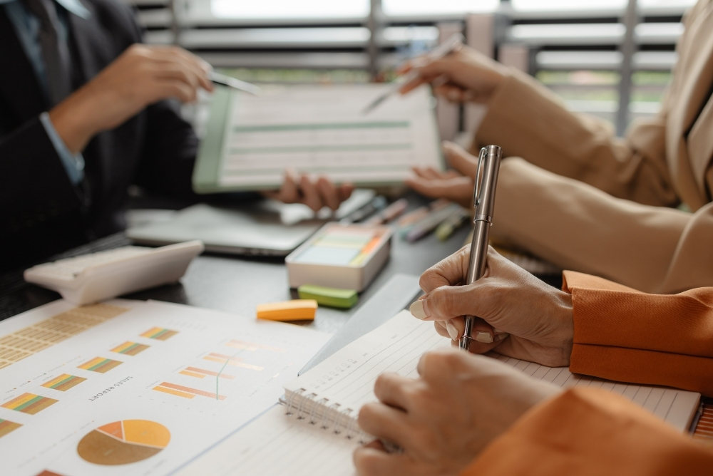 HR team reviewing charts and notes during a planning meeting for a successful employee recognition program.