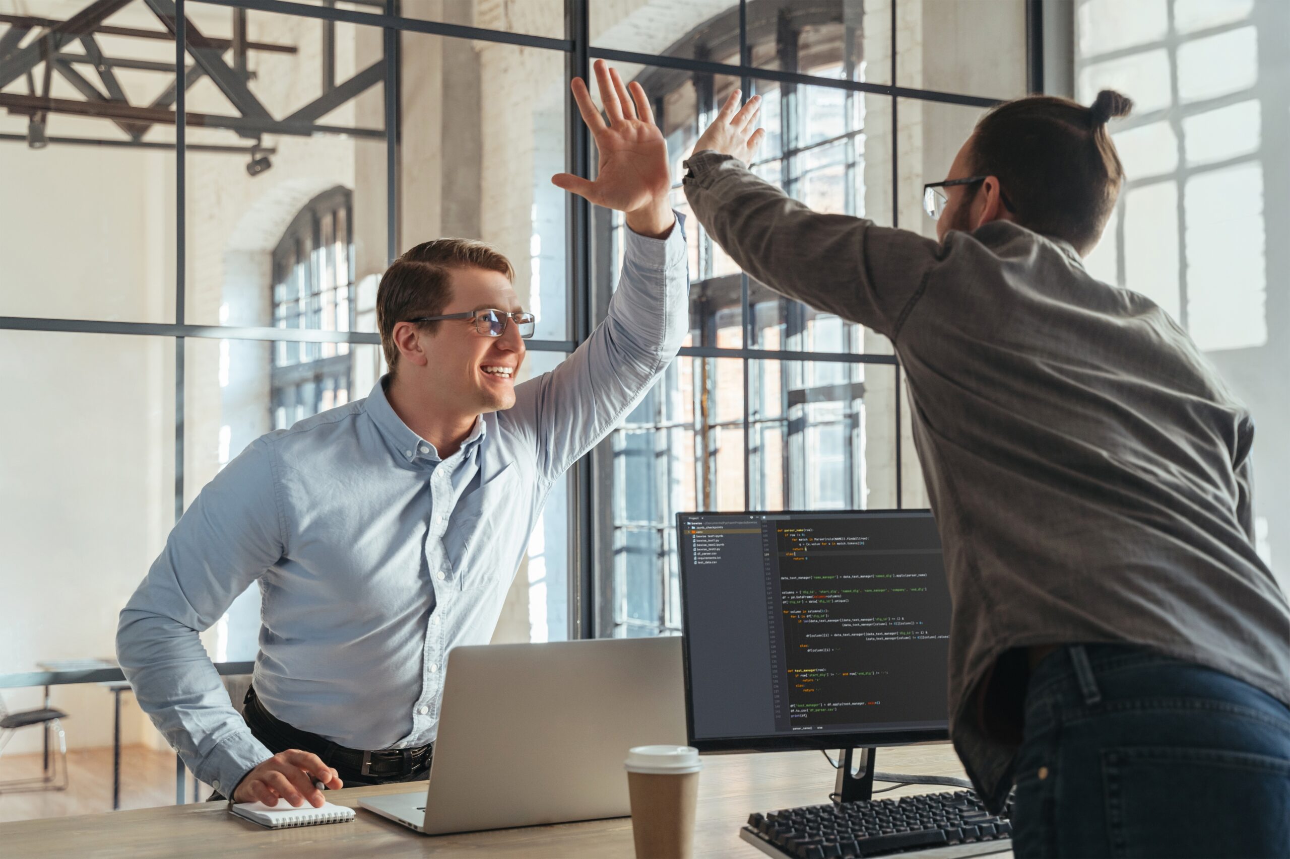 High five between coworkers celebrating recognition in the workplace.