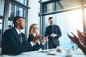 Employees applauding during a workplace recognition meeting