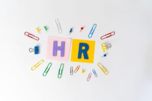 HR concept with colorful office supplies and HR letters on a clean background