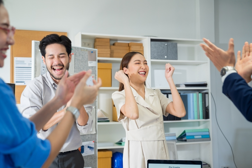 Employees celebrating workplace recognition during a team meeting