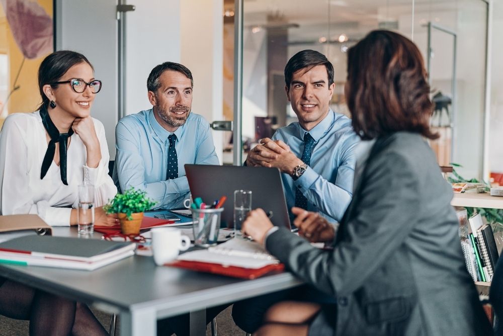Manager and employees discussing goals during a team meeting