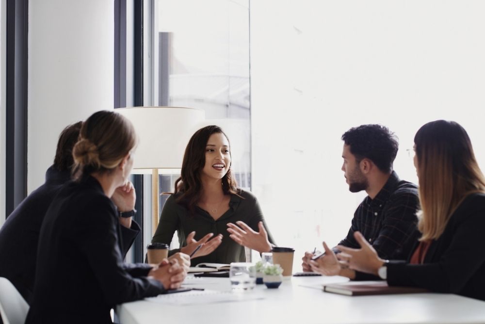 Employees having a focused workplace discussion in a team meeting