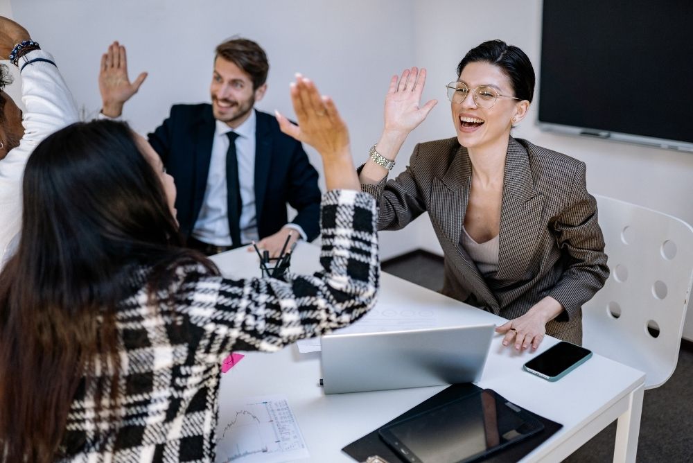 Credit union employees celebrating and recognizing a colleague during a team meeting