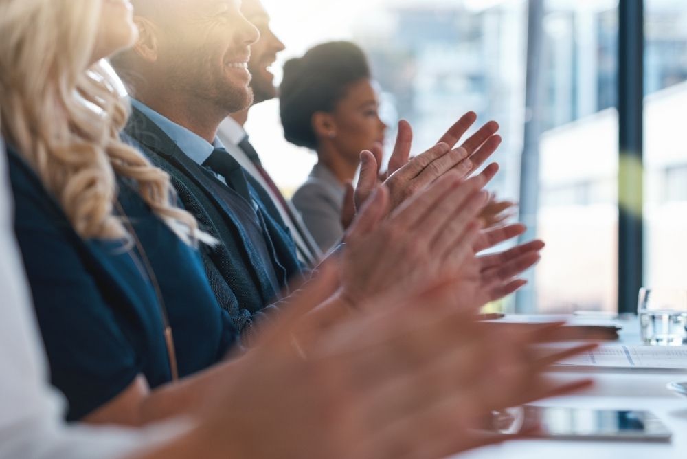 Sales team members applauding and celebrating each other's efforts